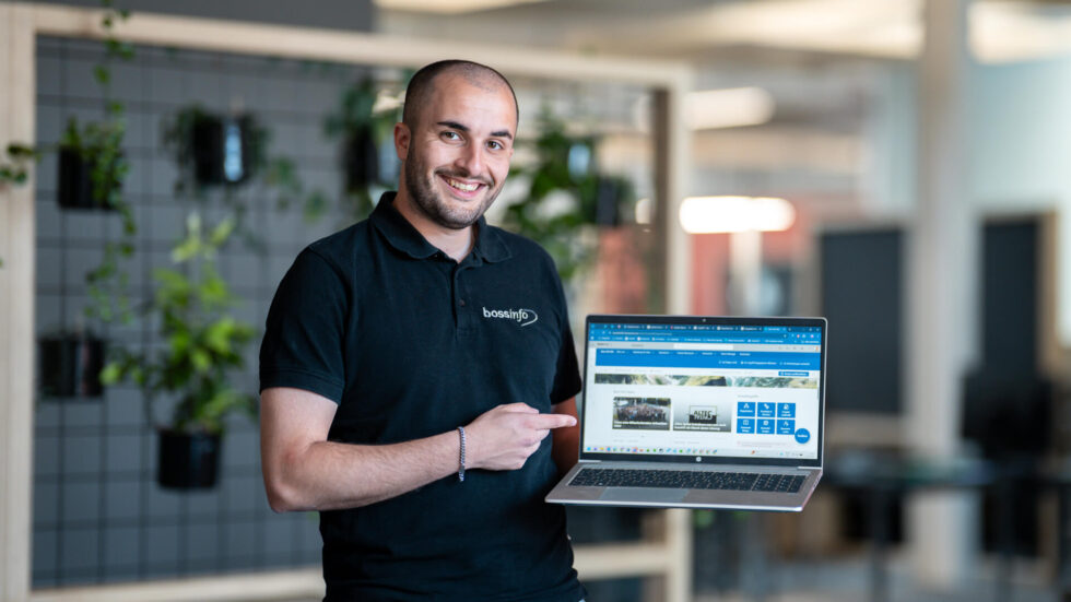 Mitarbeiter Damian zeigt auf Laptop
