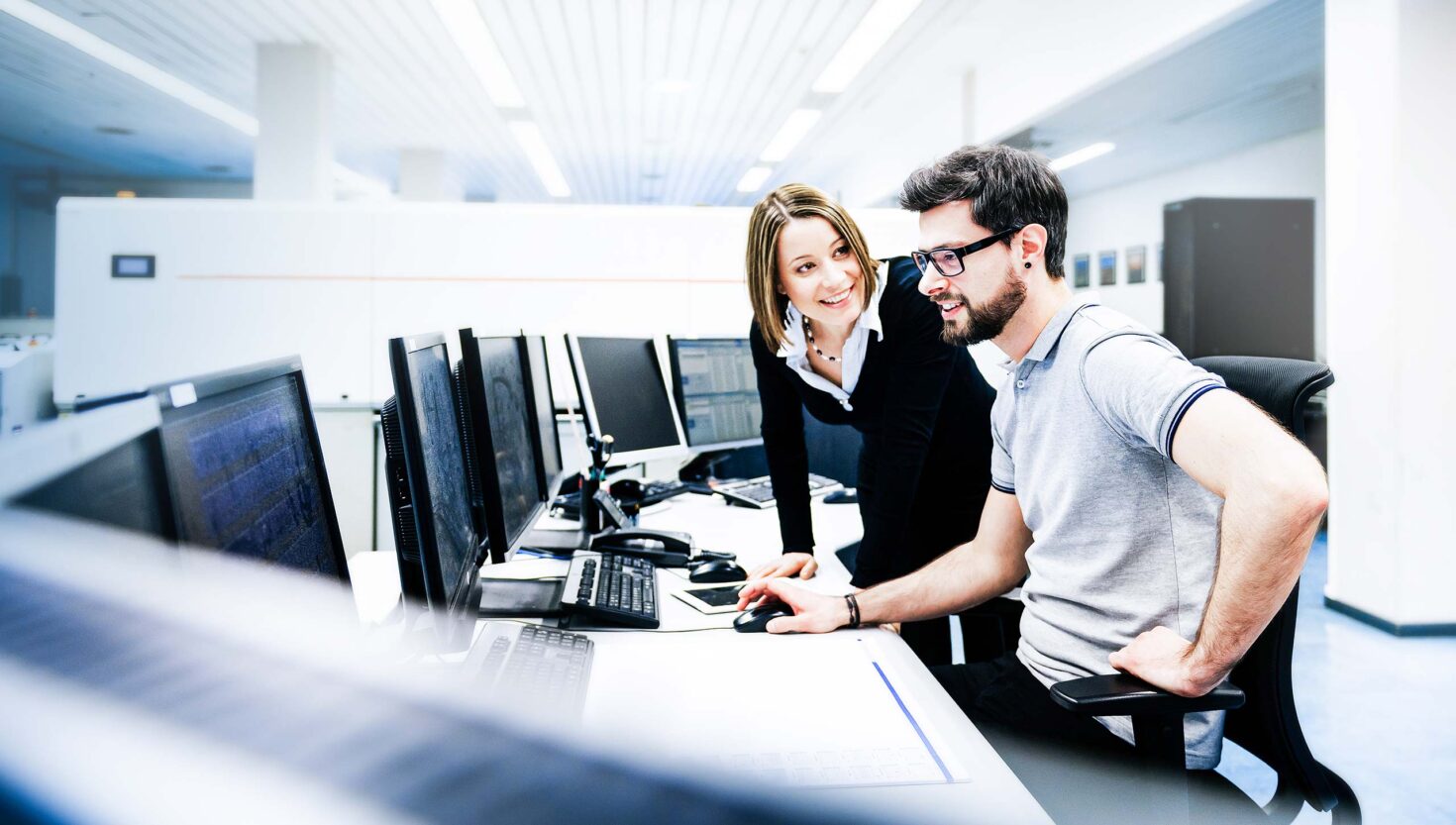 Zwei Mitarbeiter im Büro vor einem Laptop