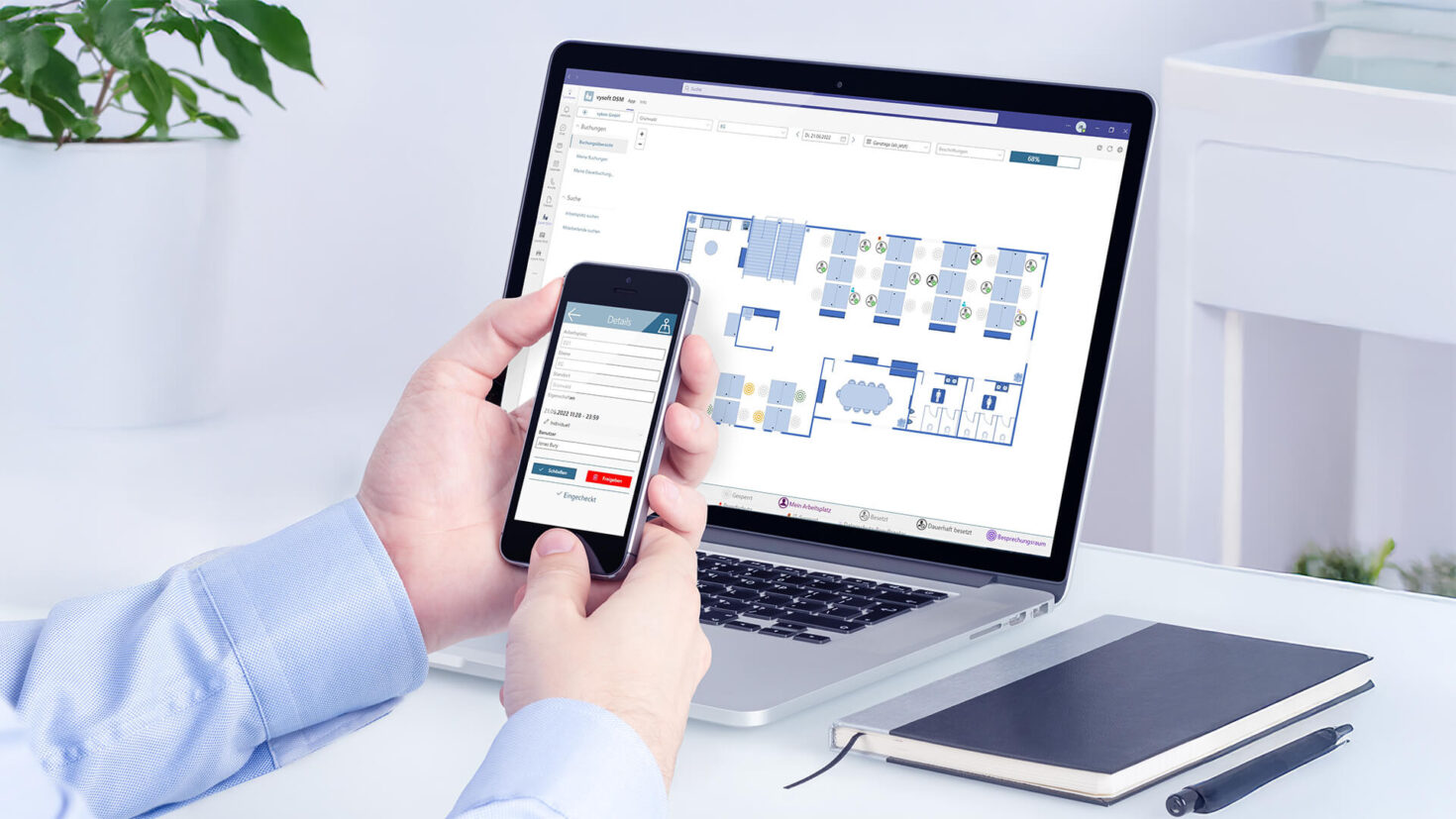 vysoft - Hand hält ein Handy vor einen Laptop